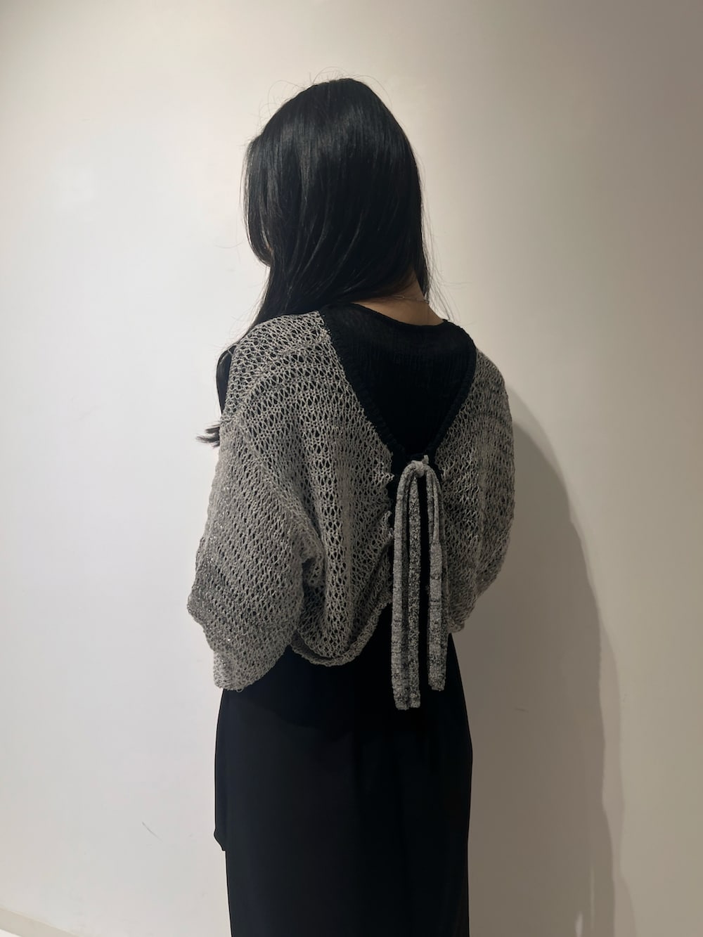 ブラック系のスカート、ホワイト系のシューズ、グレー系のカーディガン/ボレロを着用したレディースの春コーディネートの3枚目の写真