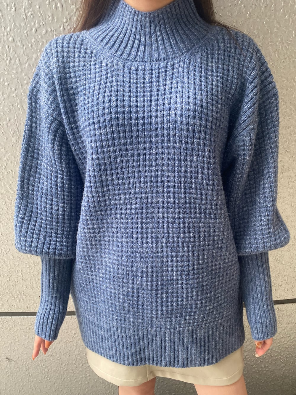 ブルー系のニット/セーター、ブラック系のキャスケットを着用したレディースの秋コーディネートの4枚目の写真