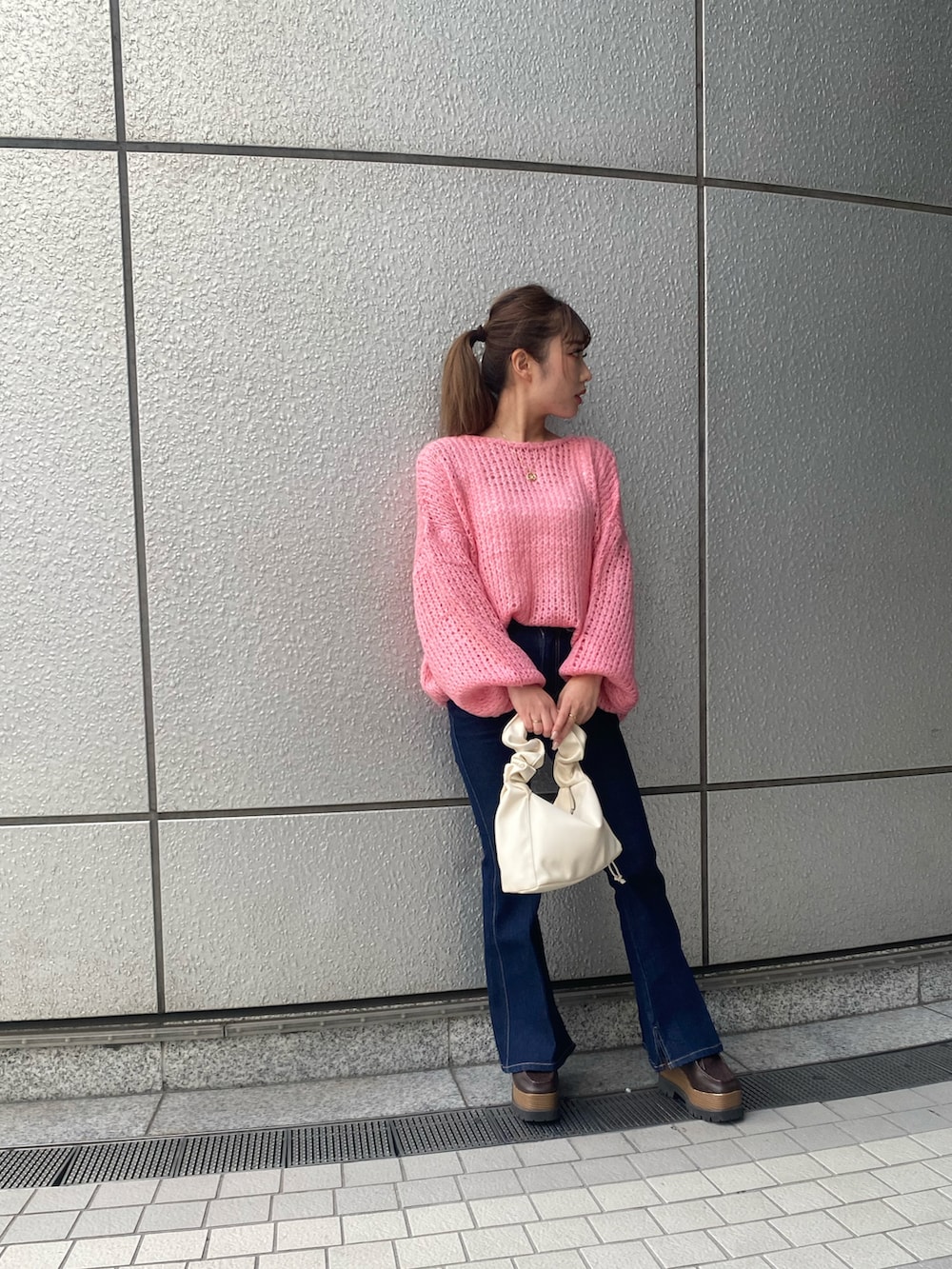 ピンク系のニット/セーター、ブルー系のデニムパンツを着用したレディースの秋コーディネートの2枚目の写真