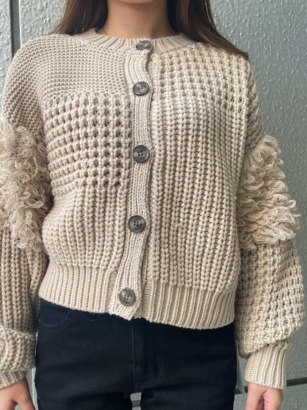 ベージュ系のカーディガン/ボレロ、ブラック系のデニムパンツを着用したレディースの秋コーディネートの3枚目の写真