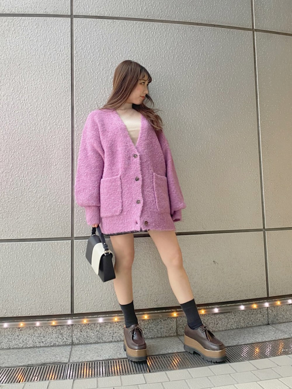 ピンク系のカーディガン/ボレロを着用したレディースの秋コーディネートの2枚目の写真