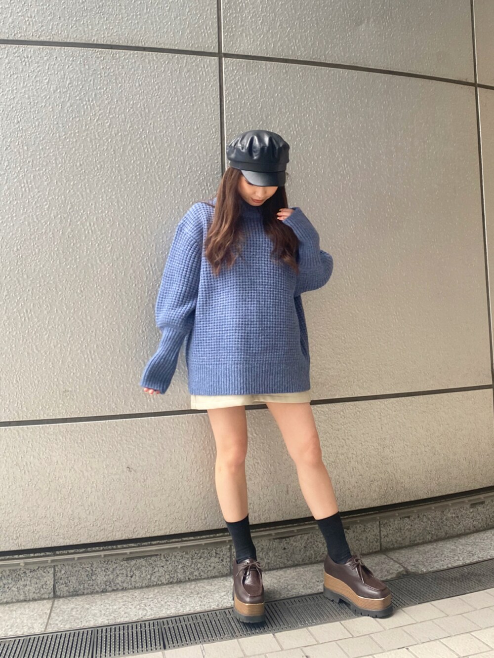 ブルー系のニット/セーター、ブラック系のキャスケットを着用したレディースの秋コーディネートの2枚目の写真