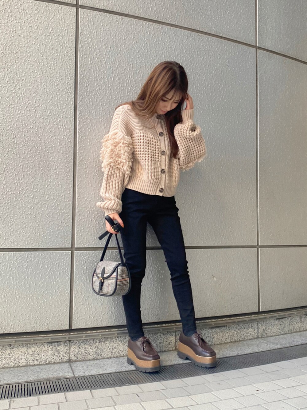 ベージュ系のカーディガン/ボレロ、ブラック系のデニムパンツを着用したレディースの秋コーディネートの2枚目の写真