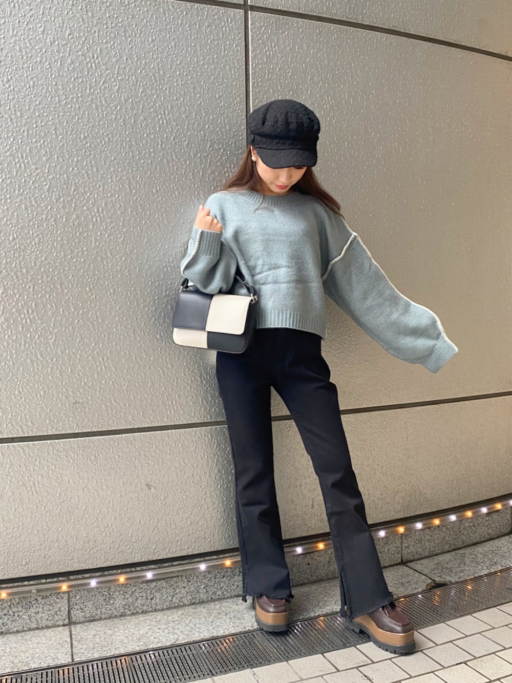 ブルー系のニット/セーター、ブルー系のデニムパンツ、ブラック系のキャスケットを着用したレディースの秋コーディネートの2枚目の写真