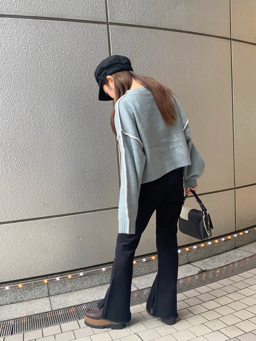 ブルー系のニット/セーター、ブルー系のデニムパンツ、ブラック系のキャスケットを着用したレディースの秋コーディネートの3枚目の写真