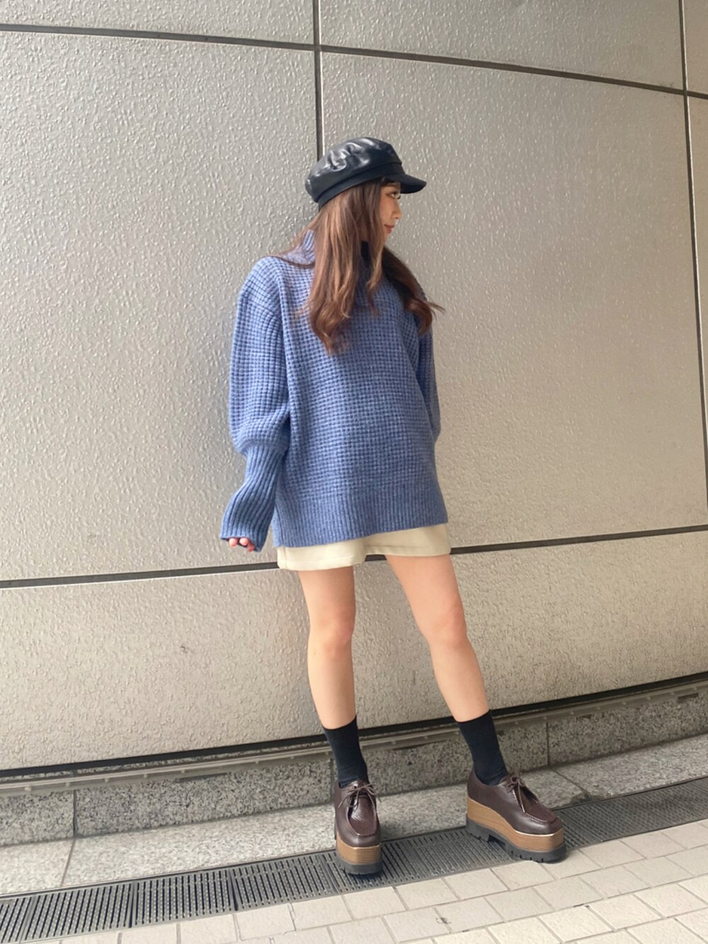ブルー系のニット/セーター、ブラック系のキャスケットを着用したレディースの秋コーディネートの3枚目の写真