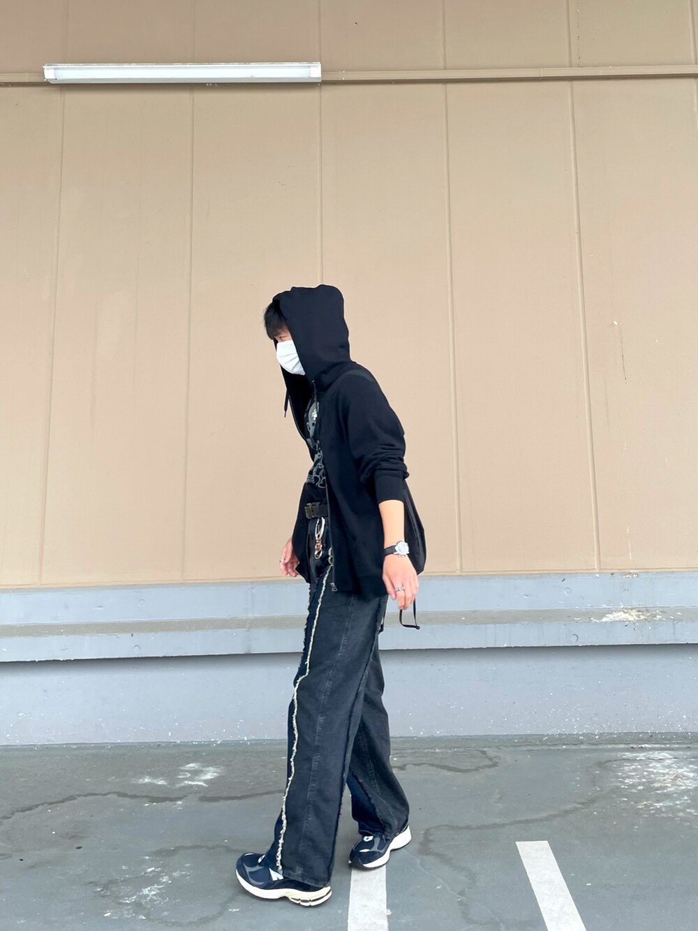 ブラック系のデニムパンツ、ブルー系のスニーカーを着用したメンズの春コーディネートの2枚目の写真