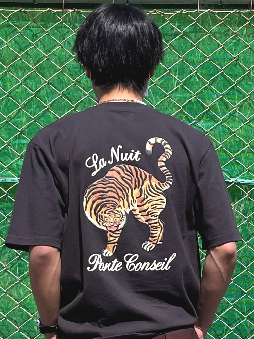 ブラック系のサンダル、ブラウン系のスラックス、ブラック系のTシャツ/カットソーを着用したメンズの春コーディネートの3枚目の写真