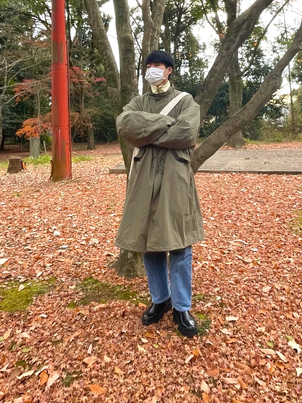 グリーン系のモッズコート、ブラック系のブーツを着用したメンズの冬コーディネートの2枚目の写真