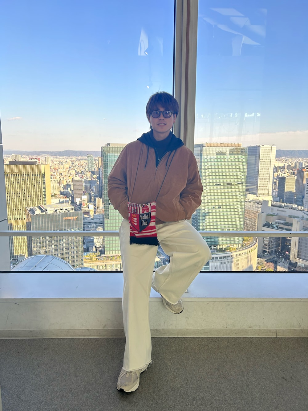 ブルー系のデニムパンツ、ベージュ系のスニーカーを着用したメンズの冬コーディネートの2枚目の写真