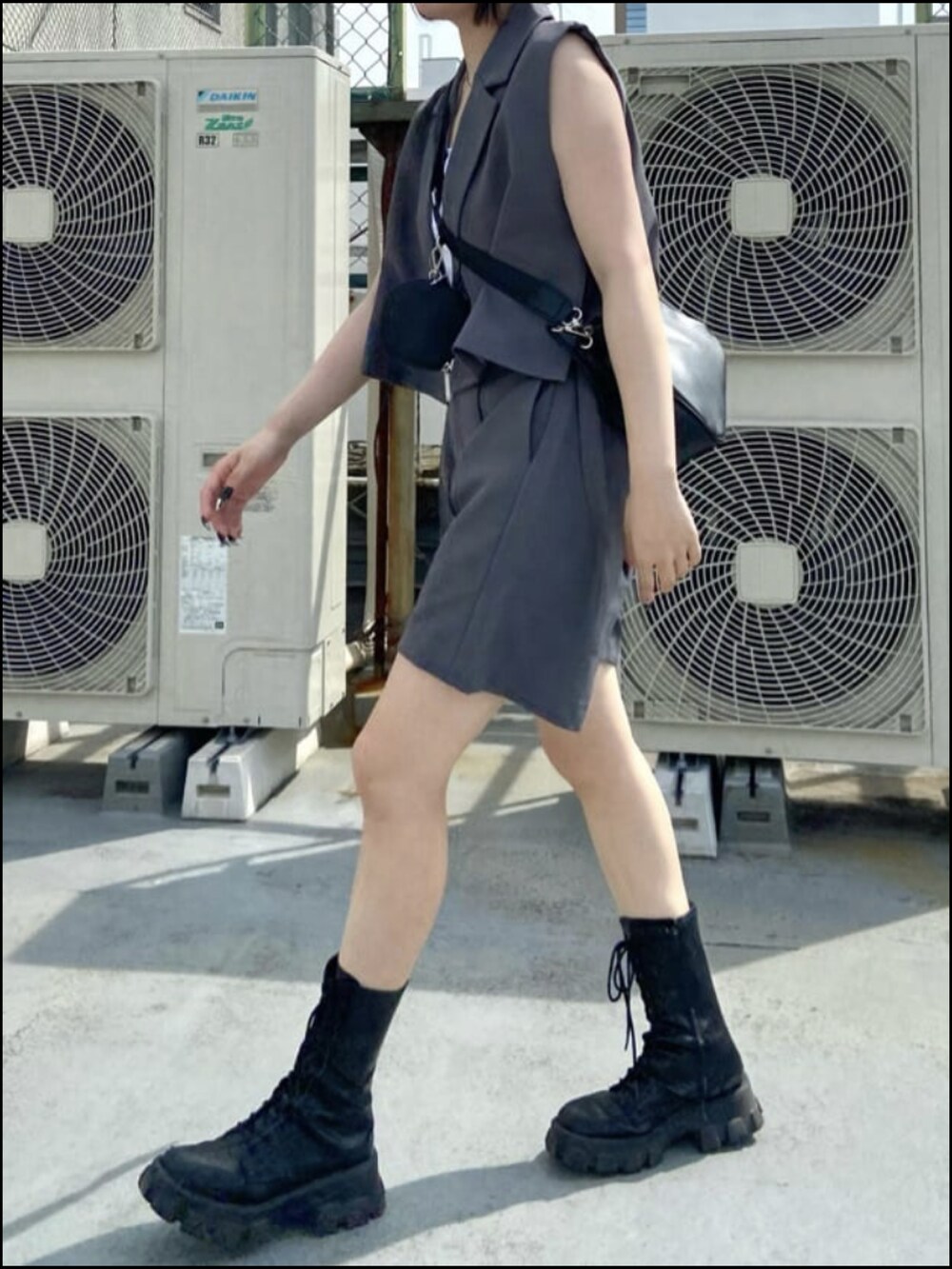 グレー系のその他パンツ、グレー系のその他アウター、ブラック系のショルダーバッグを着用したレディースの夏コーディネートの2枚目の写真