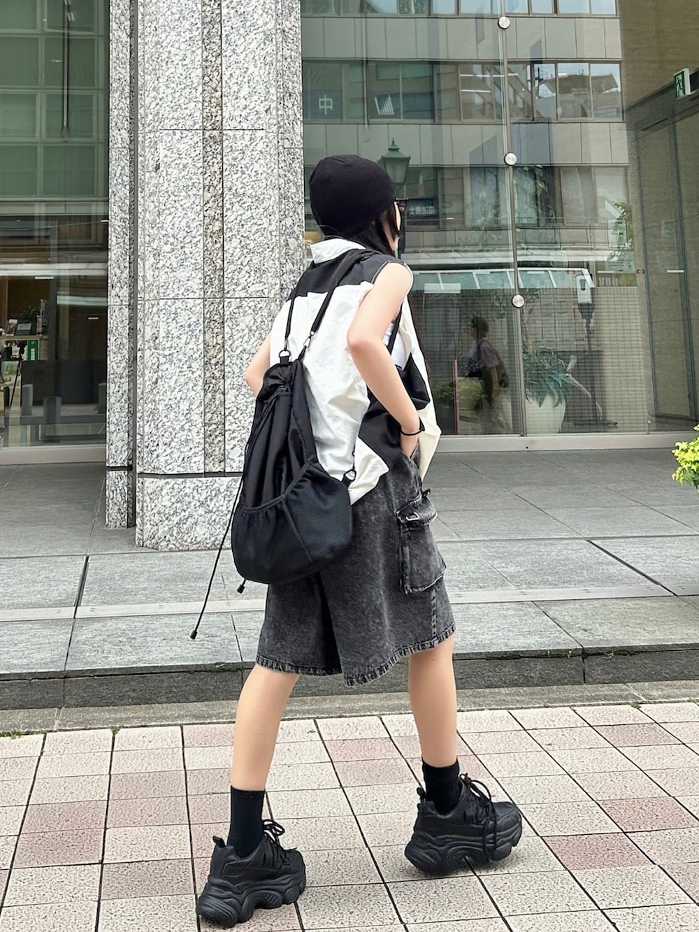 ホワイト系のベスト、ブラック系のその他パンツ、ブラック系のスニーカーを着用したレディースの夏コーディネートの2枚目の写真