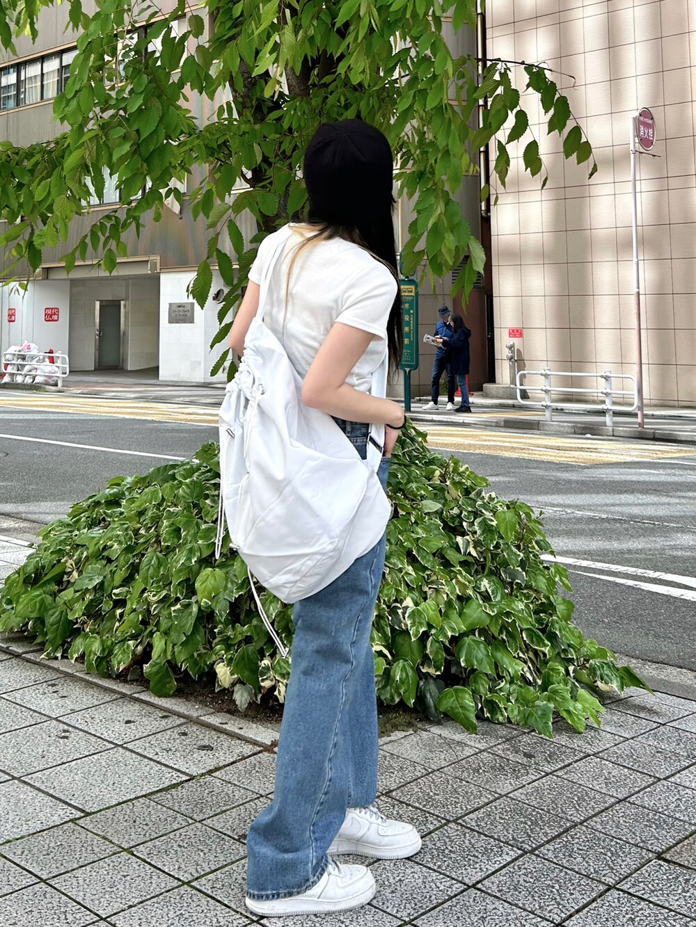 ホワイト系のTシャツ/カットソー、ホワイト系のショルダーバッグ、ブルー系のデニムパンツを着用したレディースの春コーディネートの2枚目の写真