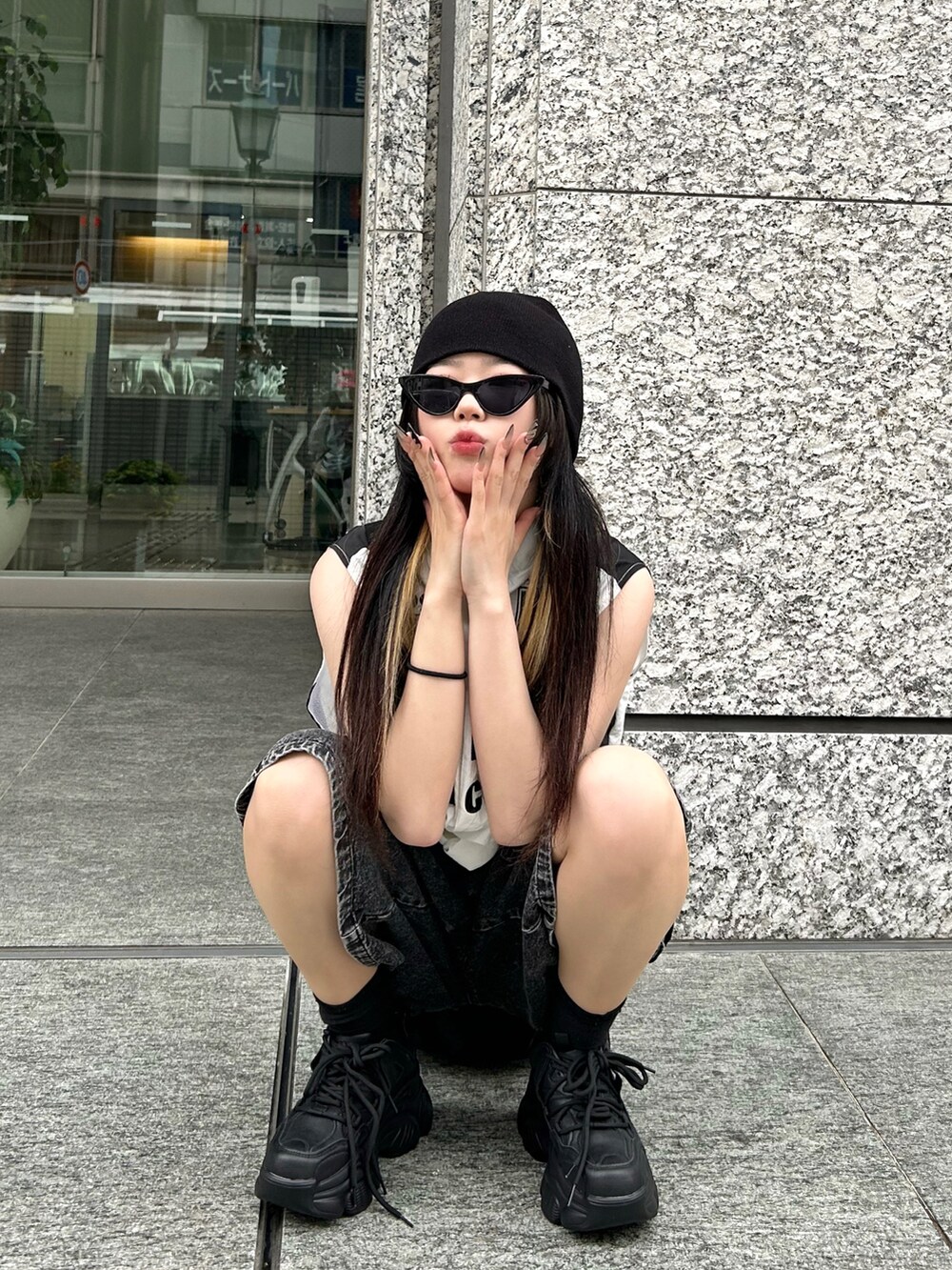 ホワイト系のベスト、ブラック系のその他パンツ、ブラック系のスニーカーを着用したレディースの夏コーディネートの3枚目の写真