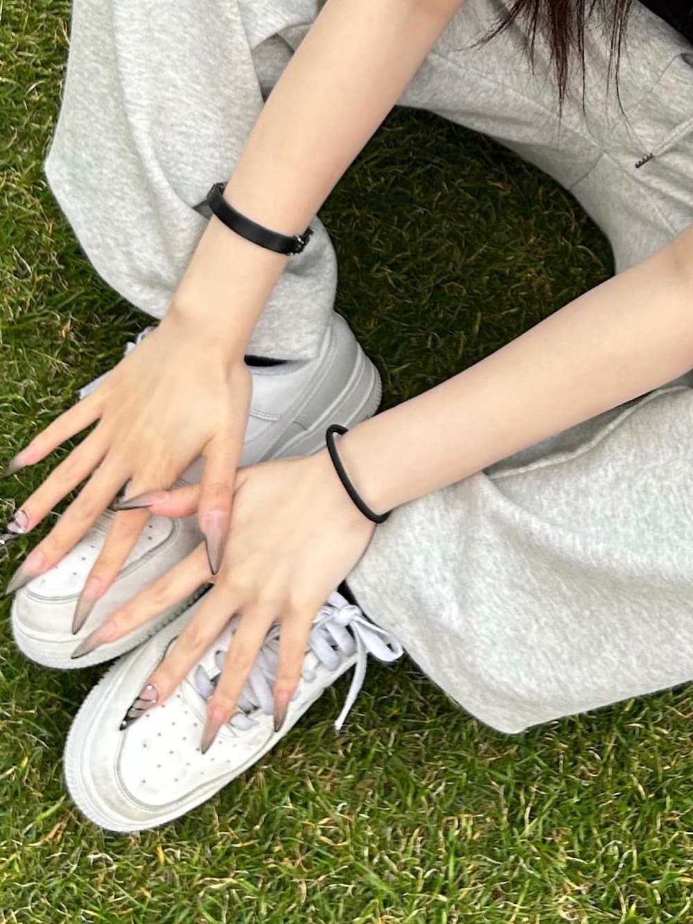 グレー系のスウェットパンツ、ホワイト系のスニーカー、ブラック系のハンドバッグを着用したレディースの夏コーディネートの2枚目の写真