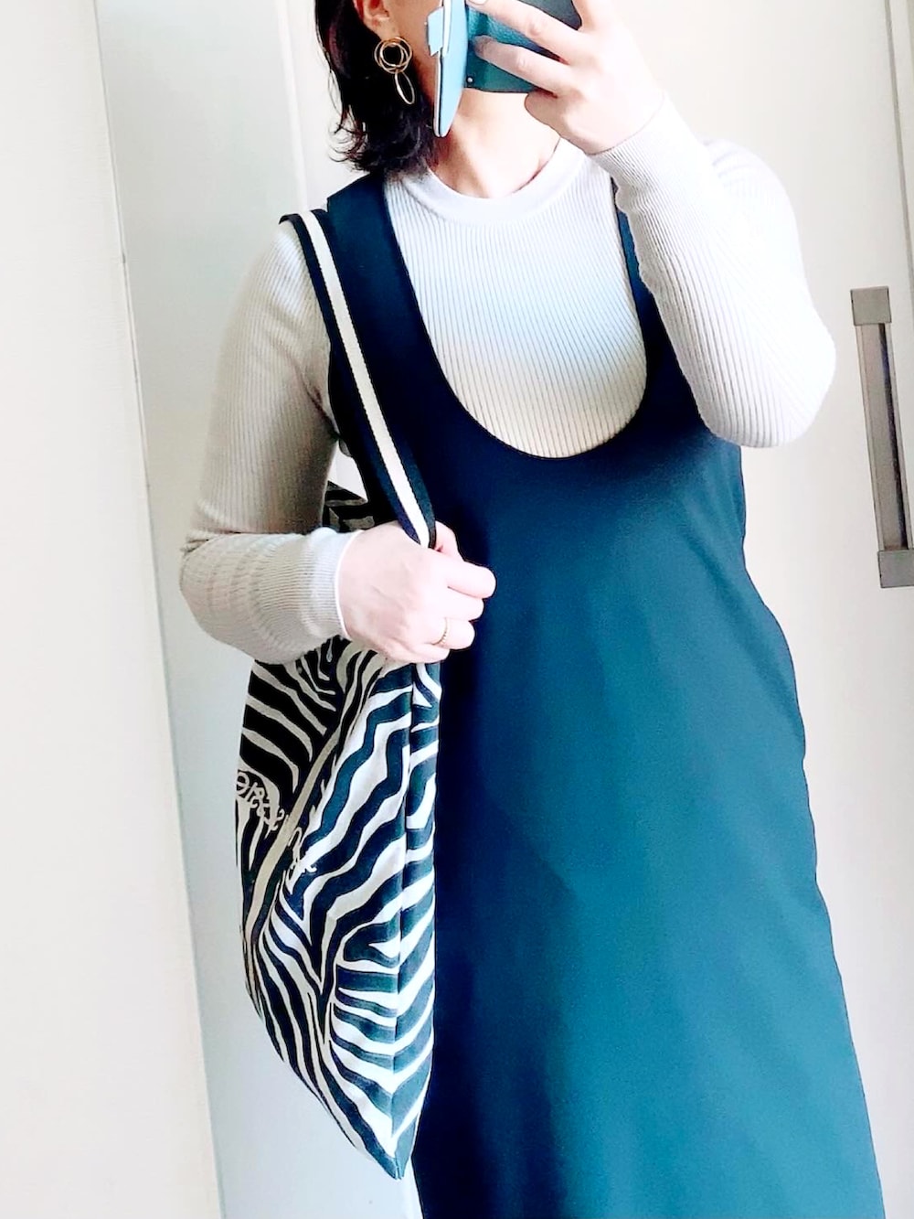 ブラック系のローファー、ブラック系のワンピース、グレー系のMA-1を着用したレディースの冬コーディネートの2枚目の写真