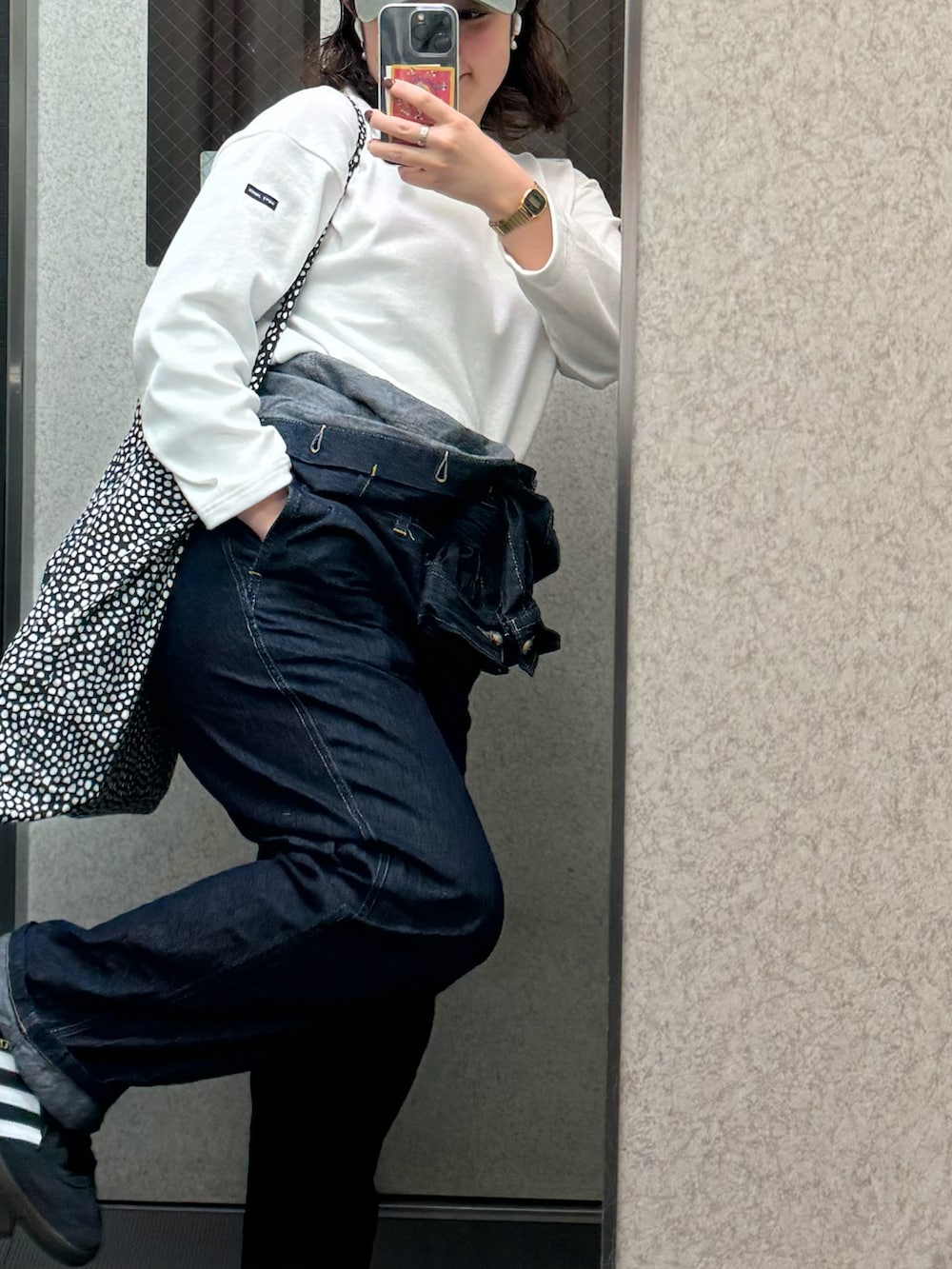 ブルー系のサロペット/オーバーオール、ブラック系のスニーカー、ホワイト系のTシャツ/カットソーを着用したレディースの春コーディネートの3枚目の写真