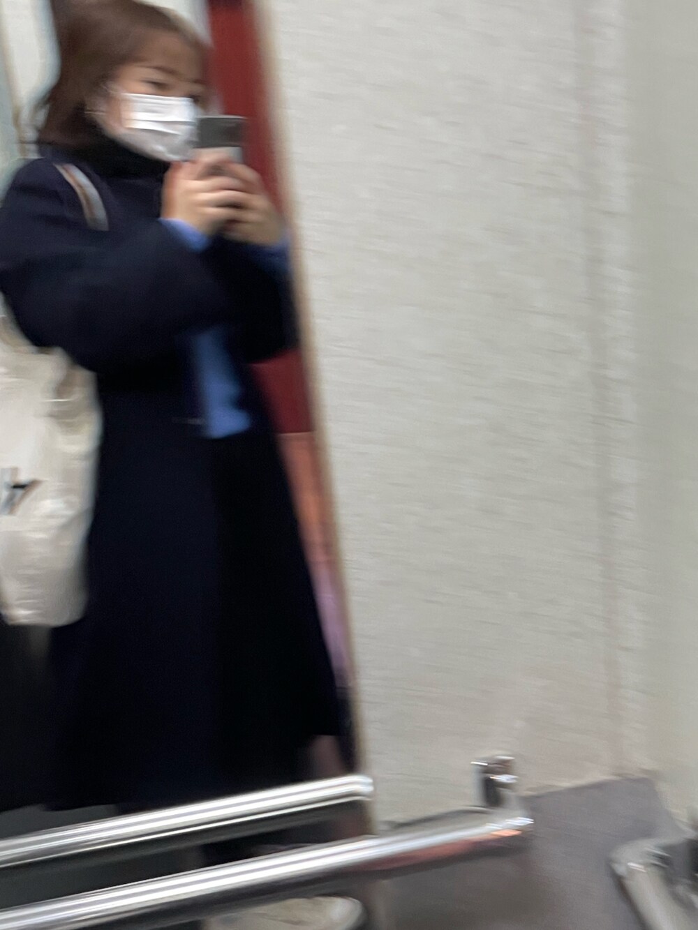 ブルー系のニット/セーター、ブラック系のノーカラーコートを着用したレディースの冬コーディネートの2枚目の写真