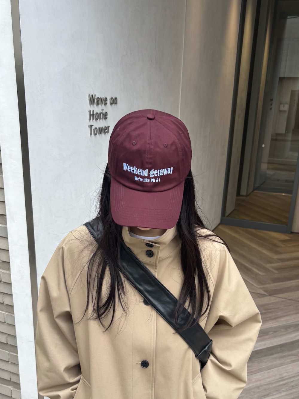 ブラック系のショルダーバッグ、ベージュ系のその他アウター、ホワイト系のスカートを着用したレディースの春コーディネートの4枚目の写真