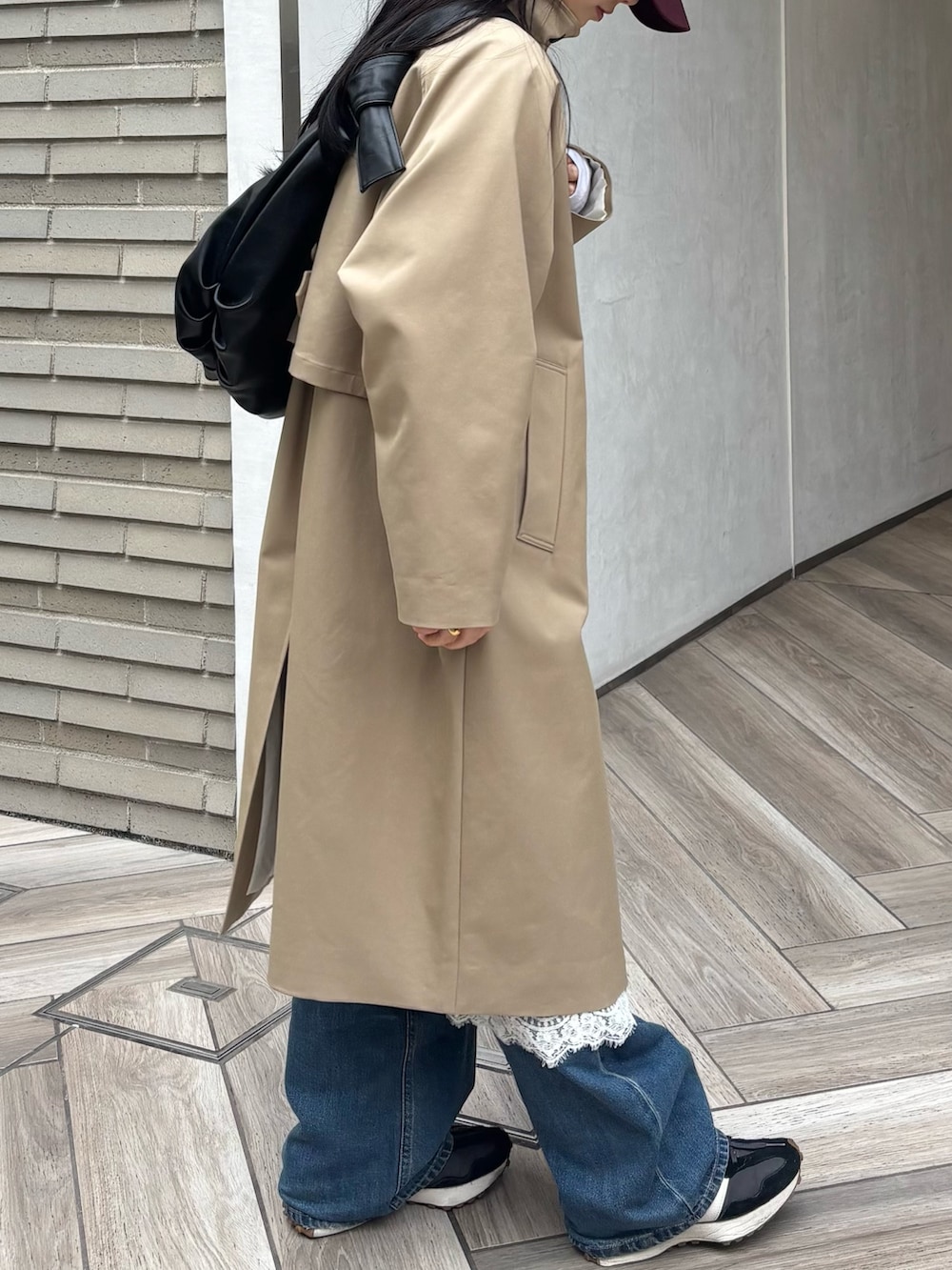 ブラック系のショルダーバッグ、ベージュ系のその他アウター、ホワイト系のスカートを着用したレディースの春コーディネートの3枚目の写真