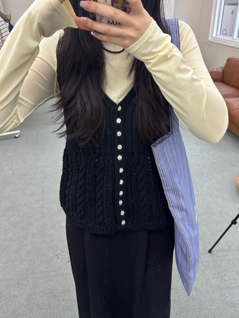 イエロー系のTシャツ/カットソー、ブラック系のベストを着用したレディースの夏コーディネートの3枚目の写真