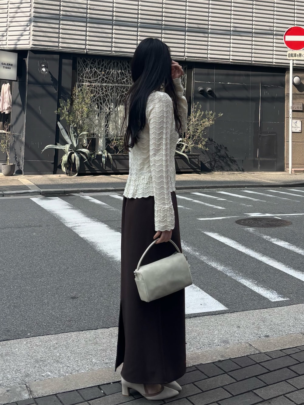 ホワイト系のニット/セーター、ブラウン系のスカートを着用したレディースの春コーディネートの2枚目の写真