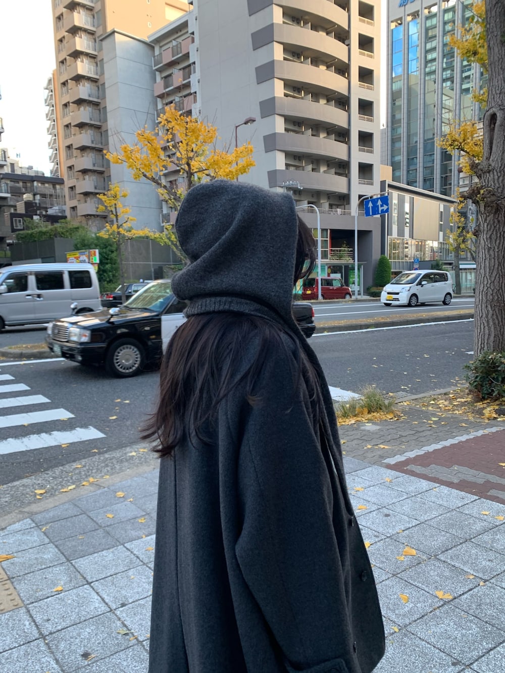 レッド系のニット/セーター、ブルー系のデニムパンツ、グレー系のステンカラーコートを着用したレディースの冬コーディネートの3枚目の写真