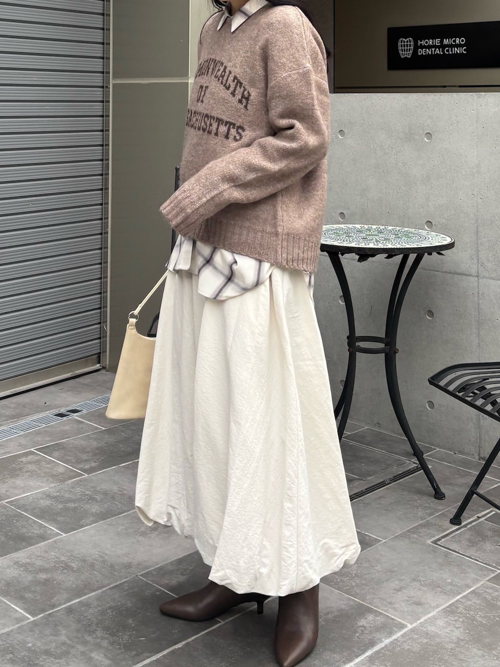 ブラウン系のニット/セーター、ホワイト系のシャツ/ブラウス、ホワイト系のスカートを着用したレディースの秋コーディネートの3枚目の写真