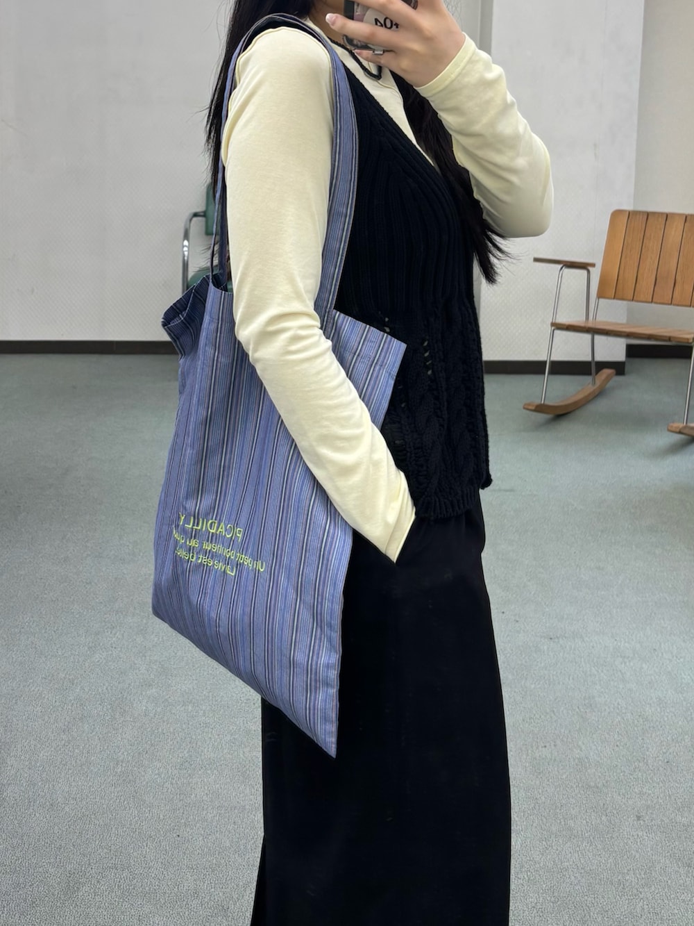 イエロー系のTシャツ/カットソー、ブラック系のベストを着用したレディースの夏コーディネートの2枚目の写真