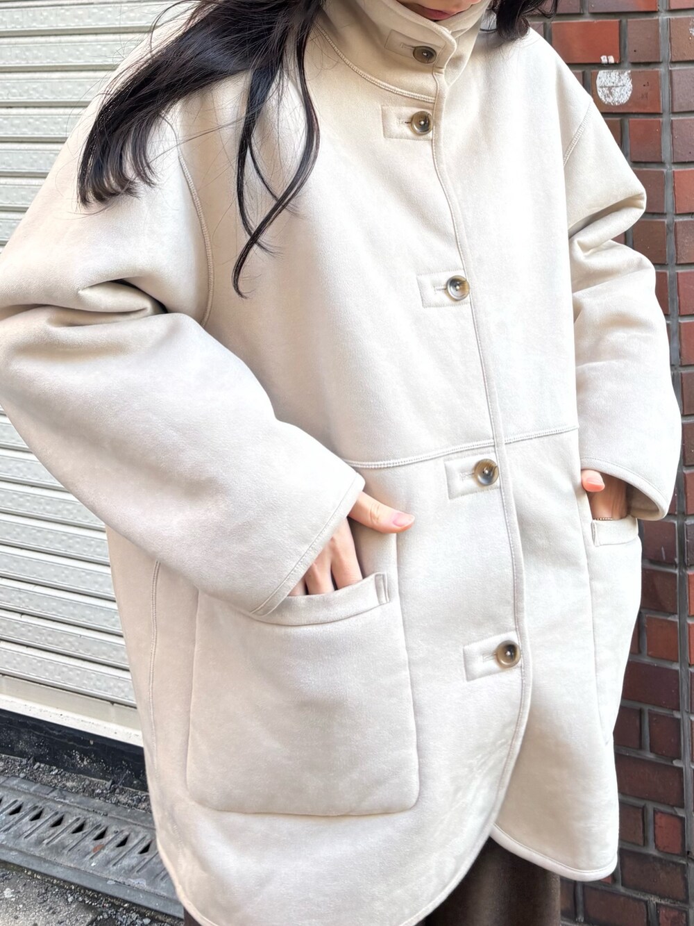 ホワイト系のムートンコート、ブラウン系のその他パンツ、ブラック系のバレエシューズを着用したレディースの冬コーディネートの2枚目の写真