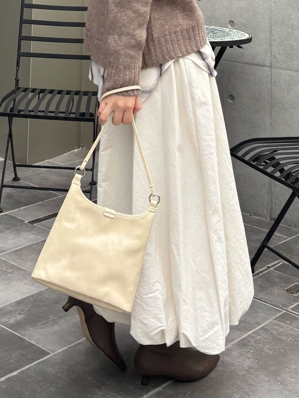 ブラウン系のニット/セーター、ホワイト系のシャツ/ブラウス、ホワイト系のスカートを着用したレディースの秋コーディネートの2枚目の写真