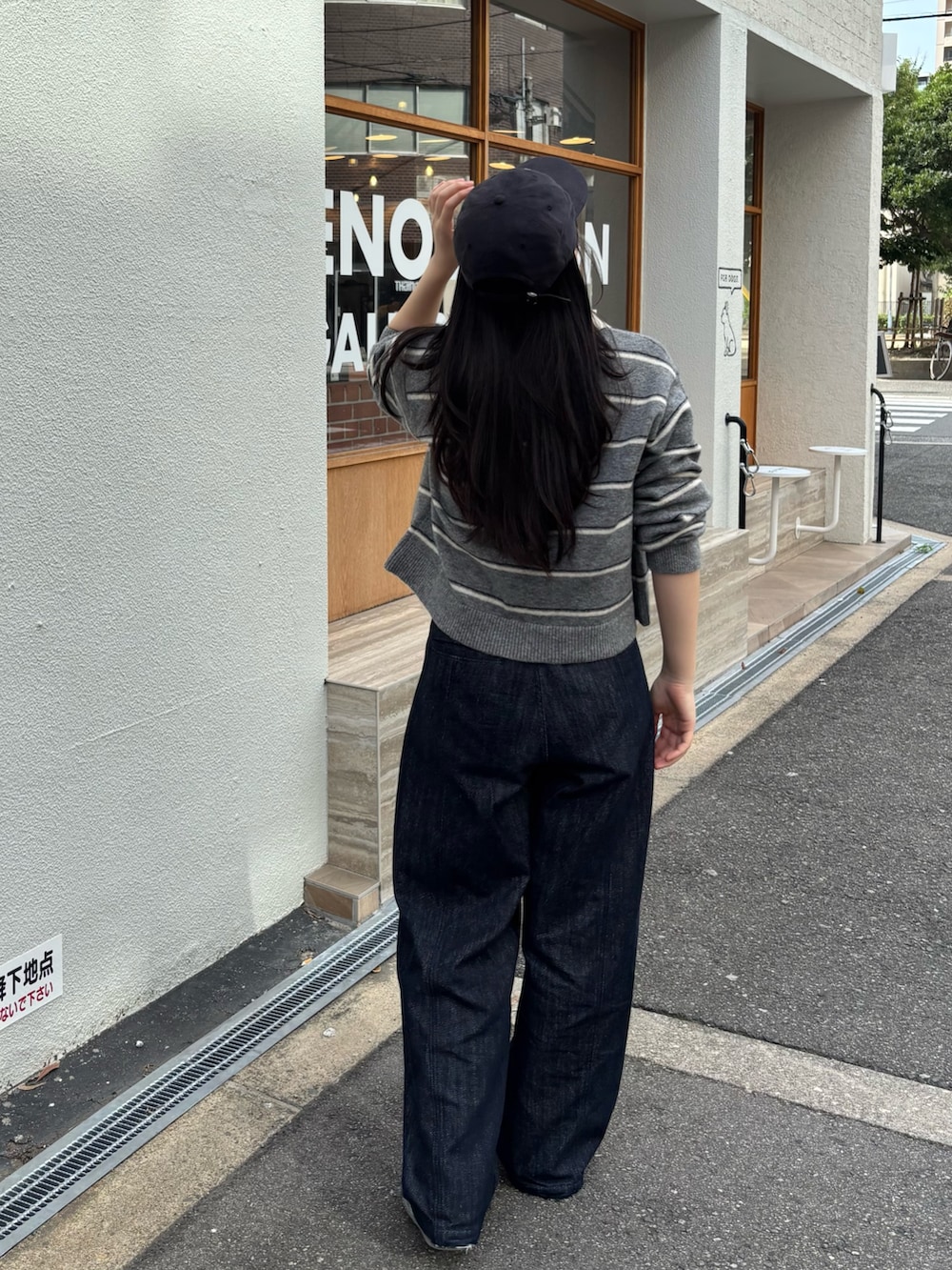 グレー系のニット/セーター、グレー系のスニーカー、ブラック系のキャップを着用したレディースの秋コーディネートの2枚目の写真