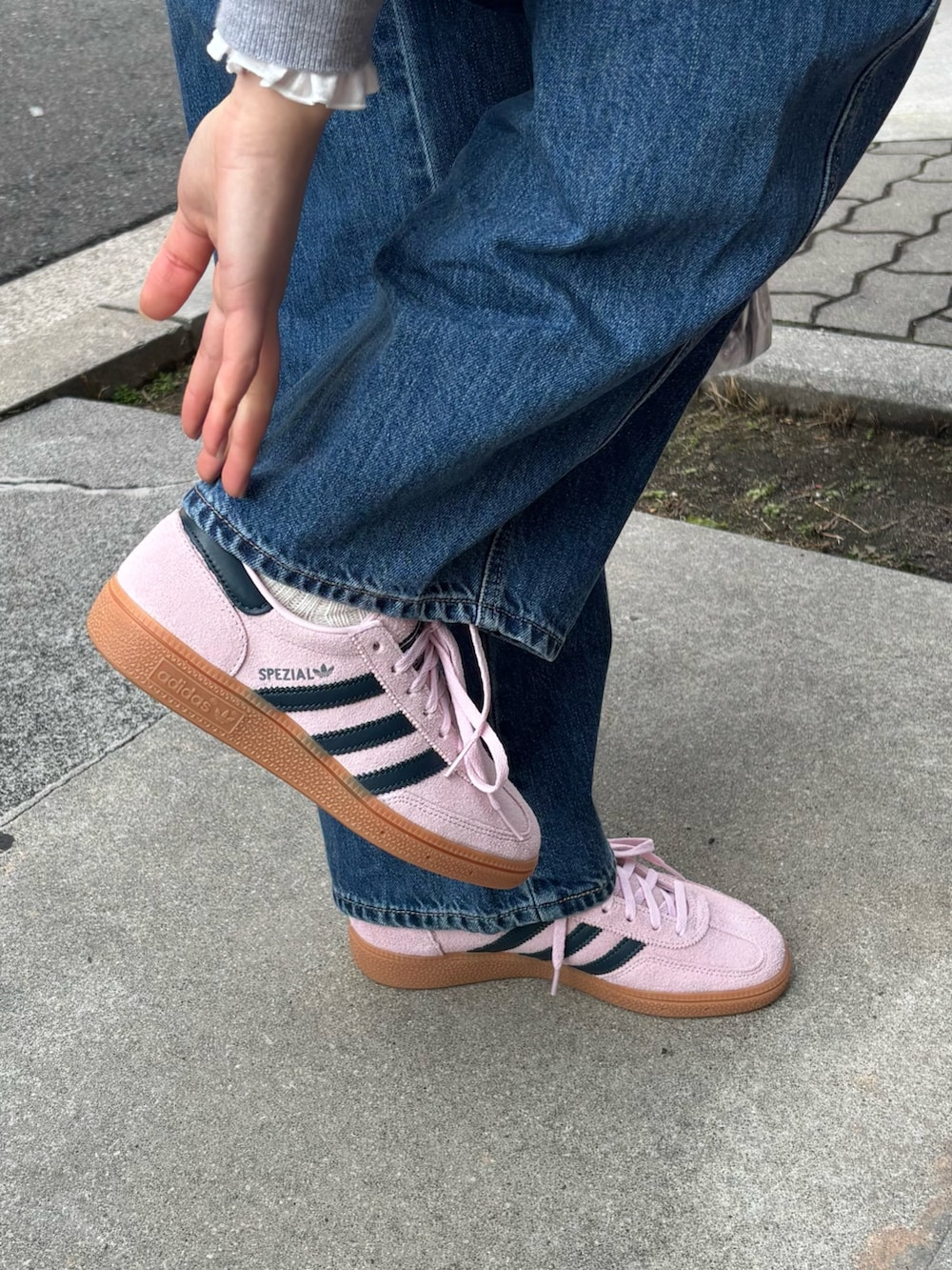 ブルー系のデニムパンツ、グレー系のニット/セーター、ホワイト系のシャツ/ブラウスを着用したレディースの冬コーディネートの3枚目の写真