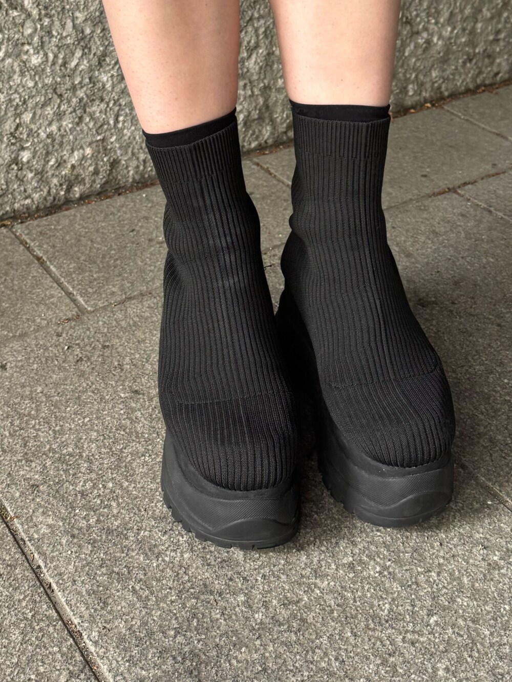 ブラック系のTシャツ/カットソー、ベージュ系のスカート、ブラック系のブーツを着用したレディースの春コーディネートの7枚目の写真