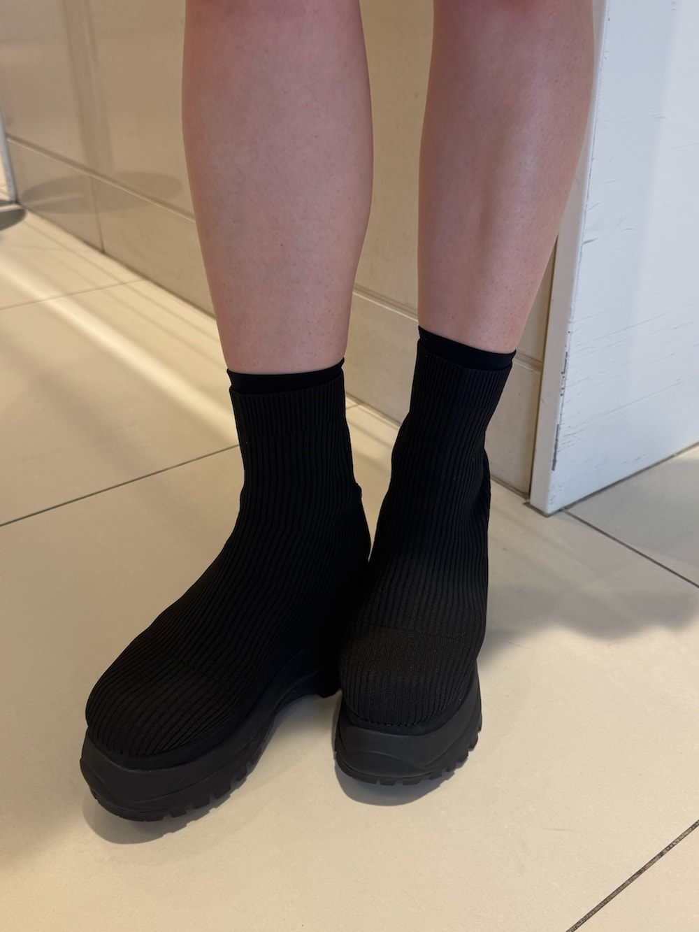 ホワイト系のシャツ/ブラウス、グレー系のスカート、ブラック系のブーツを着用したレディースの春コーディネートの8枚目の写真