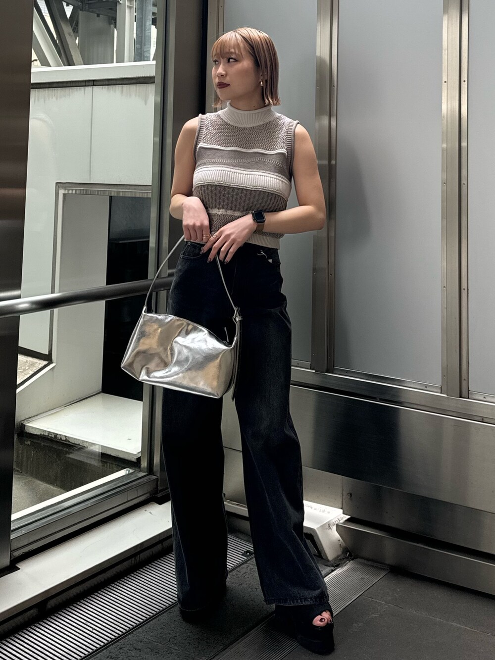 グレー系のニット/セーター、ブラック系のデニムパンツを着用したレディースの春コーディネートの3枚目の写真