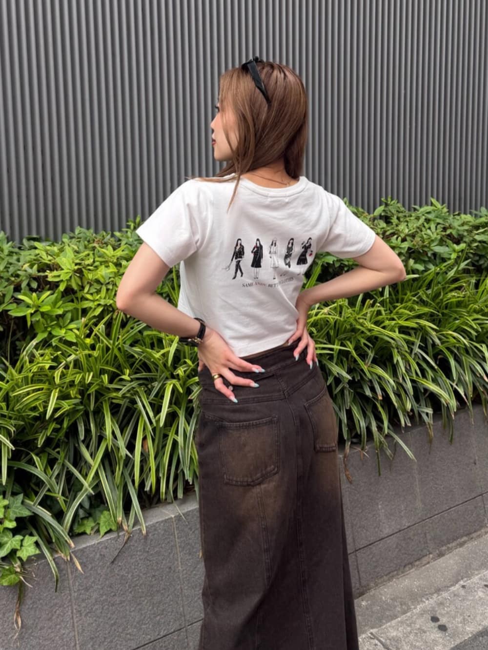 ブラック系のブーツ、ブラウン系のデニムスカート、ホワイト系のTシャツ/カットソーを着用したレディースの夏コーディネートの5枚目の写真