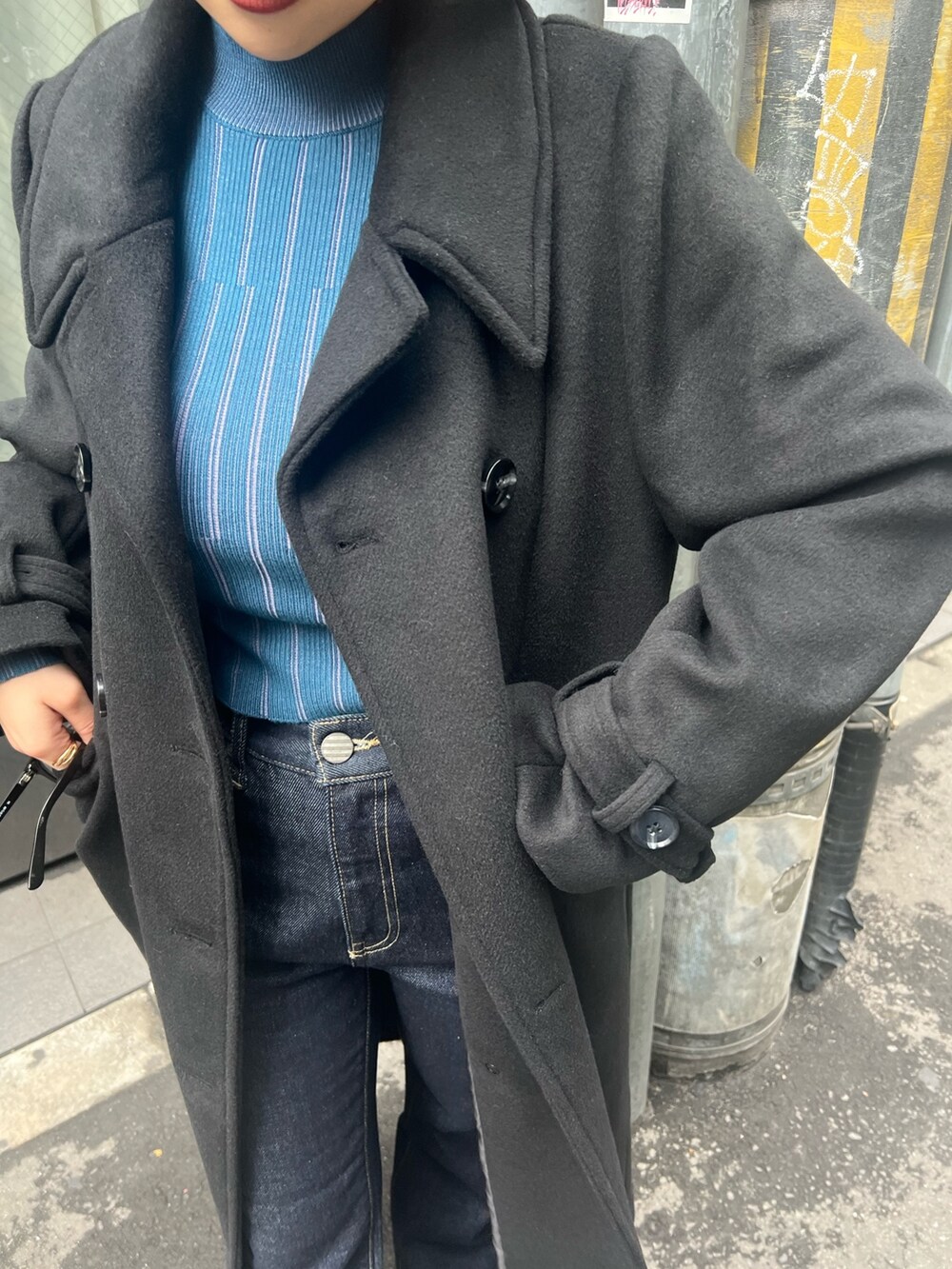 ブラック系のチェスターコートを着用したレディースの秋コーディネートの6枚目の写真