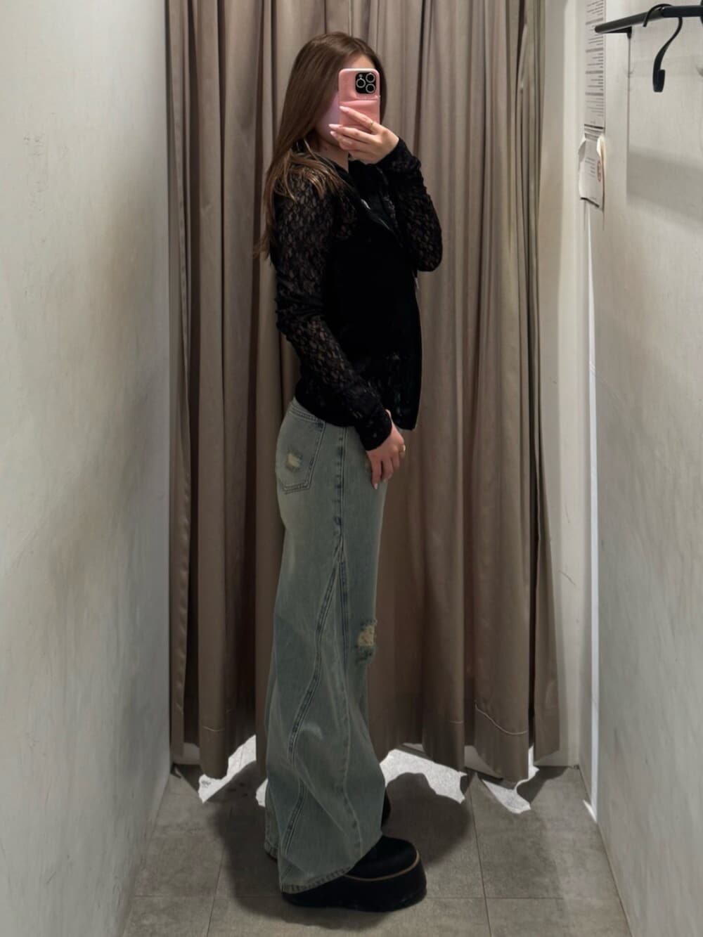 ブラック系のブーツ、ブルー系のデニムパンツ、ブラック系のパーカーを着用したレディースの春コーディネートの2枚目の写真