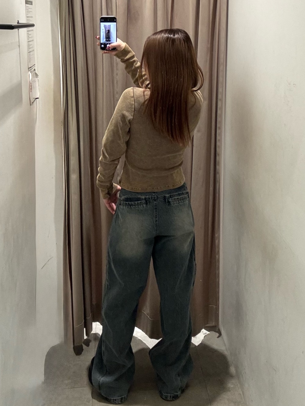 ブルー系のデニムパンツ、ブラウン系のTシャツ/カットソー、ブラック系のブーツを着用したレディースの冬コーディネートの3枚目の写真