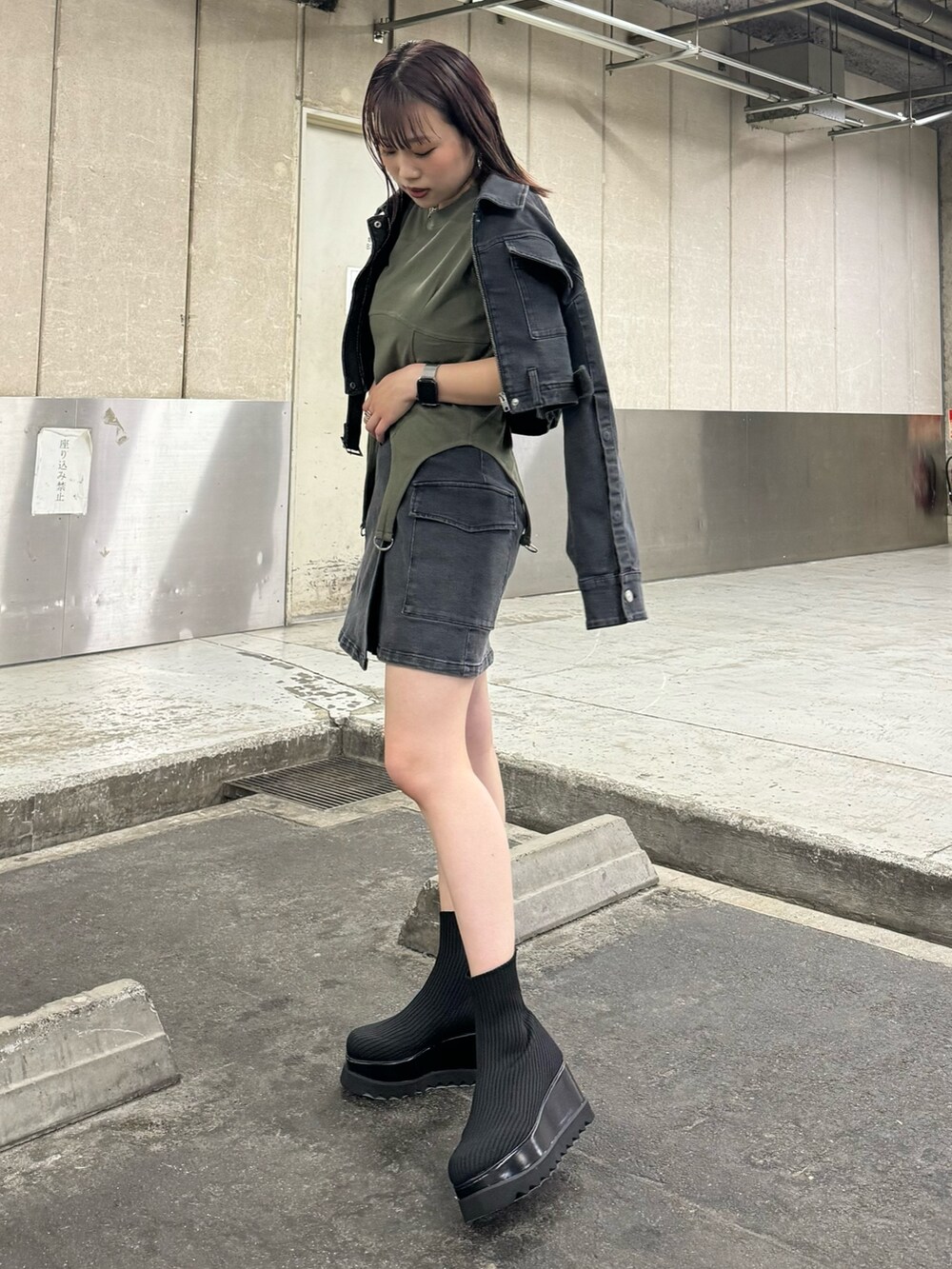 ブラック系のデニムジャケット、ブラック系のスカート、グリーン系のTシャツ/カットソーを着用したレディースの夏コーディネートの3枚目の写真