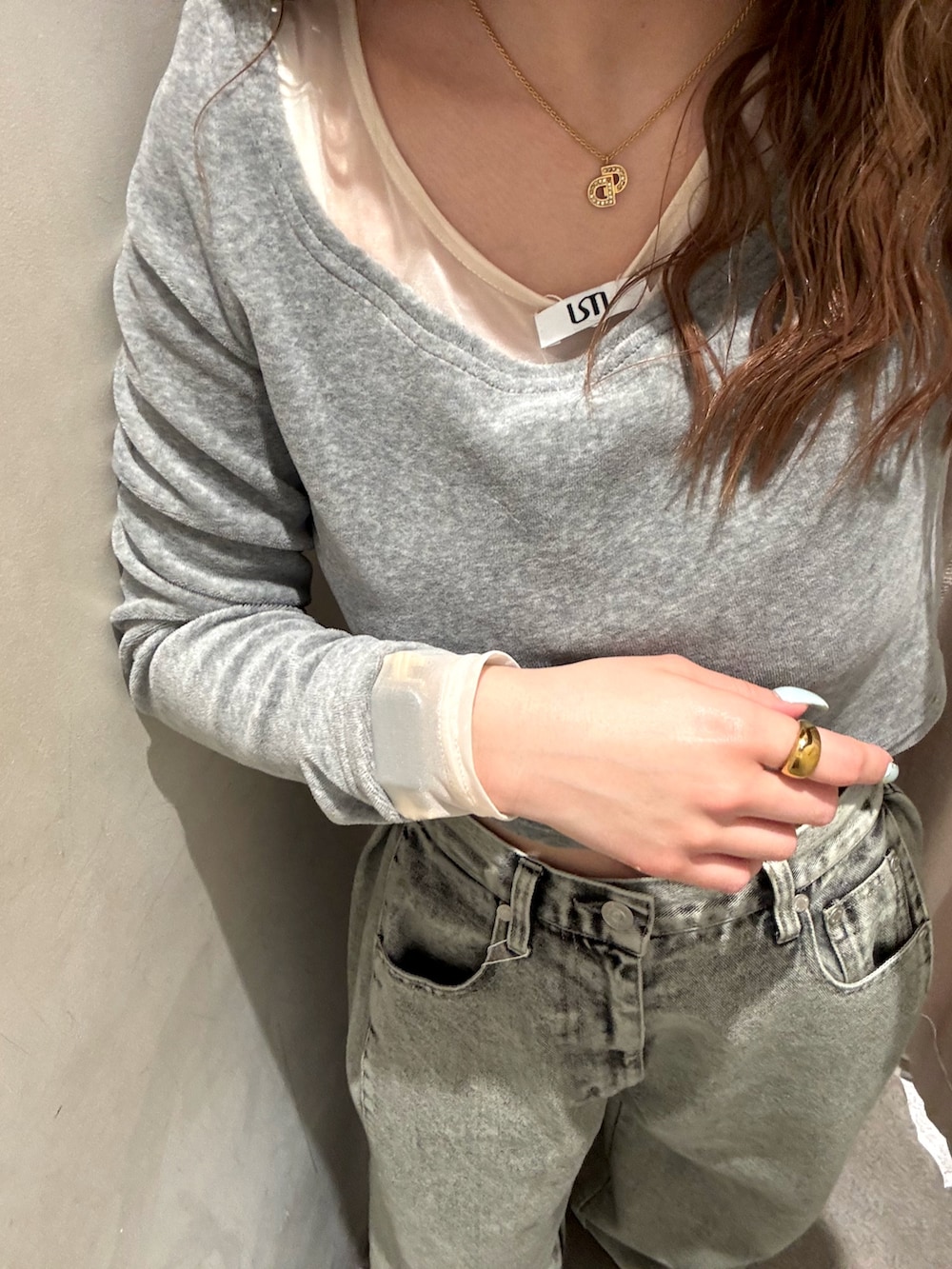 グレー系のTシャツ/カットソー、グリーン系のデニムパンツ、ブラック系のブーツを着用したレディースの冬コーディネートの5枚目の写真