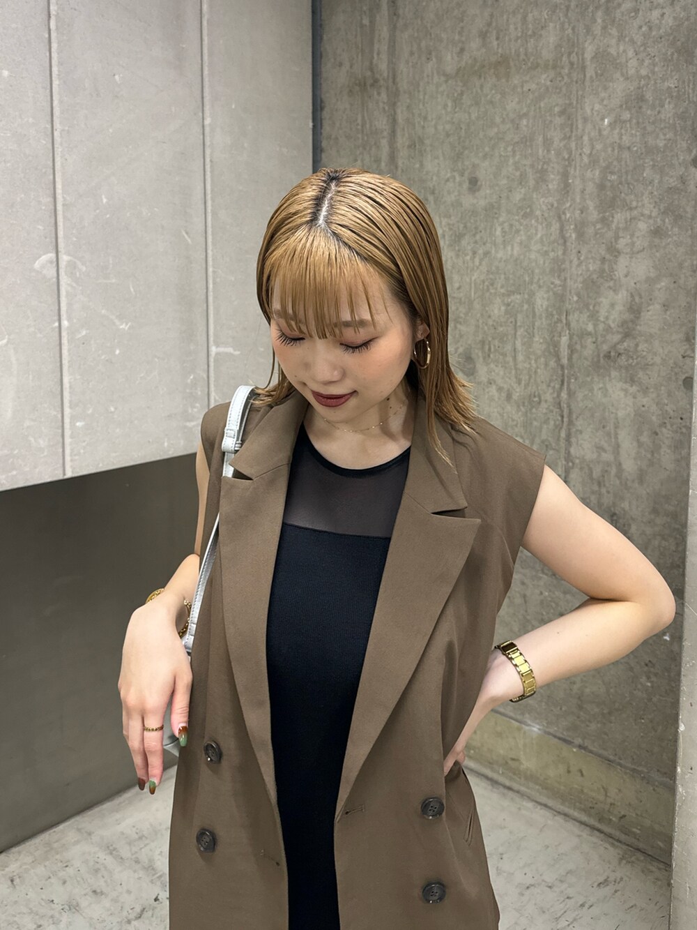 ブラウン系のベスト、ブラック系のワンピース、シルバー系のハンドバッグを着用したレディースの夏コーディネートの5枚目の写真