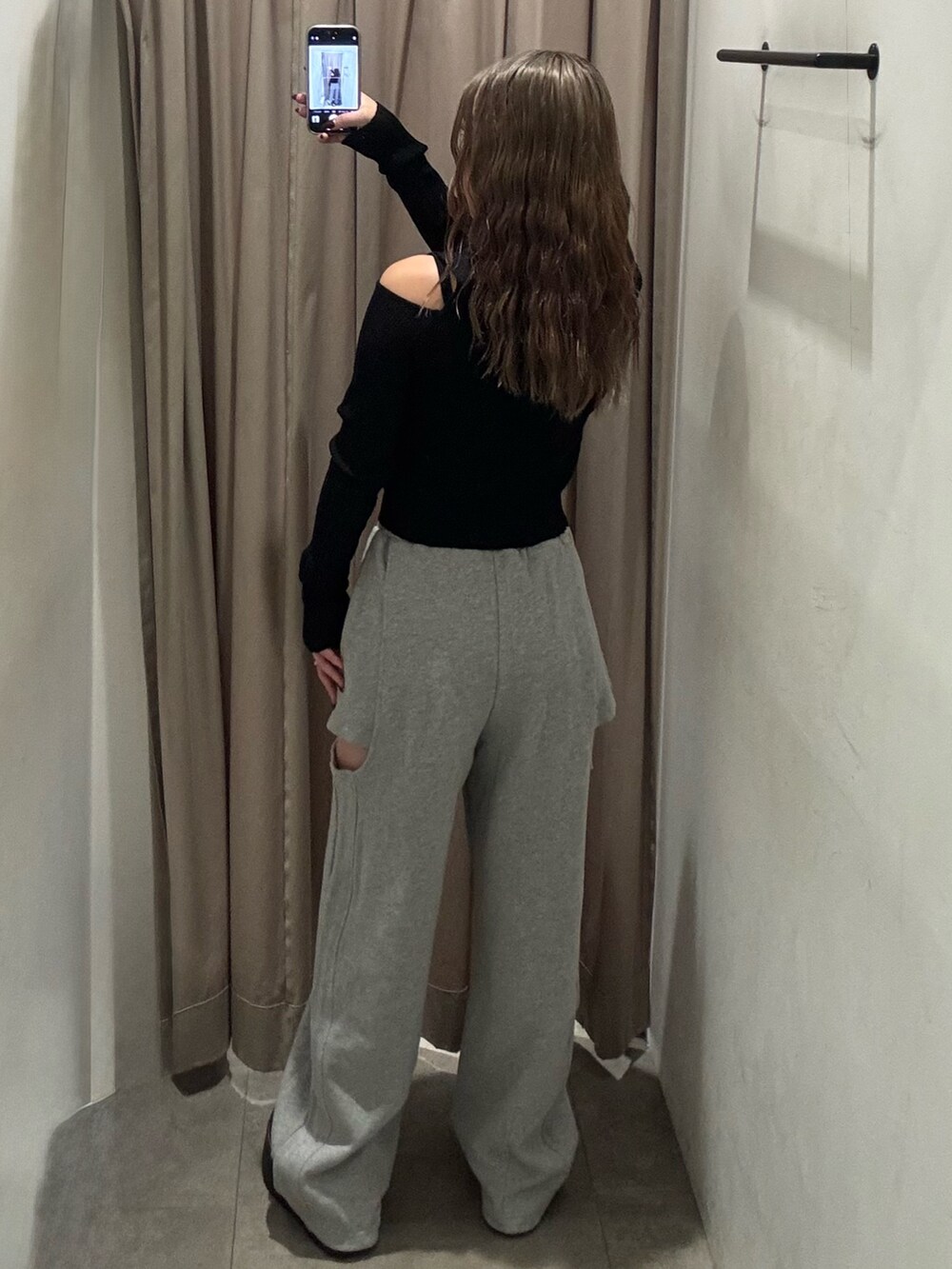 グレー系のスウェットパンツ、ブラック系のニット/セーター、ブラック系のブーツを着用したレディースの秋コーディネートの3枚目の写真