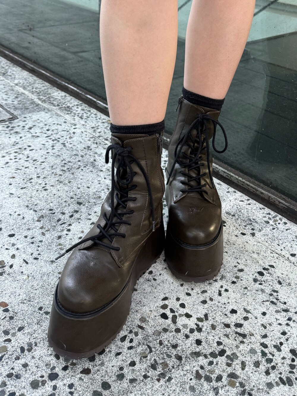 グレー系のスウェット、ブラック系のスカート、ブラック系のハンドバッグを着用したレディースの秋コーディネートの7枚目の写真