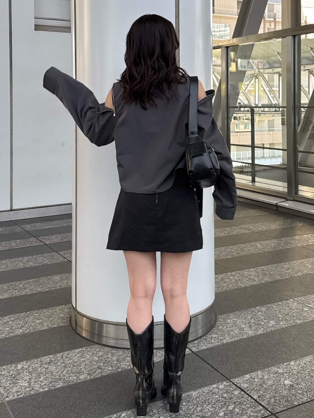 グレー系のシャツ/ブラウス、ブラック系のスカート、ブラウン系のブーツを着用したレディースの春コーディネートの3枚目の写真