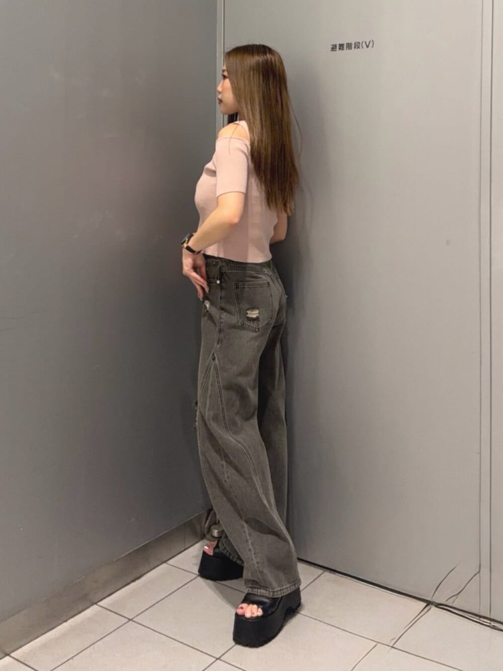 グレー系のデニムパンツ、ブラック系のブーツ、ピンク系のニット/セーターを着用したレディースの春コーディネートの2枚目の写真
