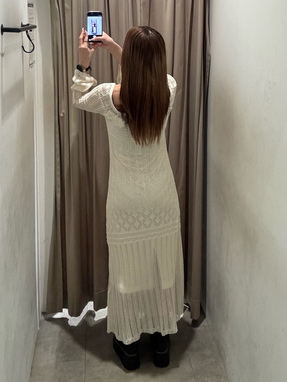 ホワイト系のワンピース、ブラック系のブーツを着用したレディースの春コーディネートの3枚目の写真