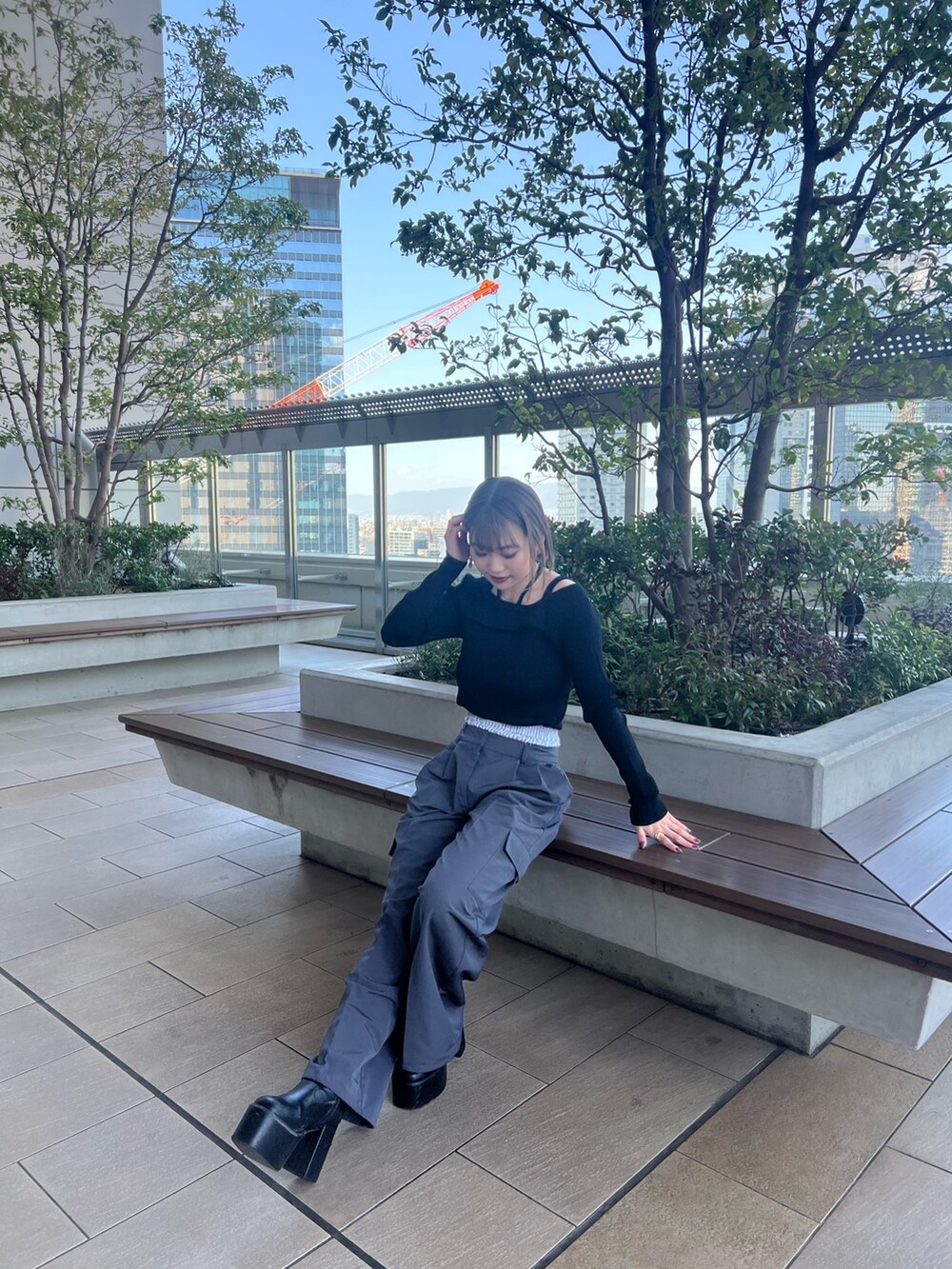 ブラック系のニット/セーター、グレー系のその他パンツを着用したレディースの春コーディネートの3枚目の写真