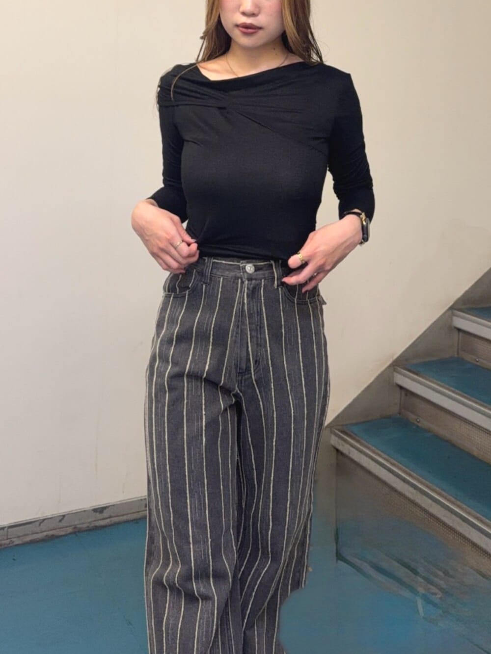 ブラック系のブーツ、ブラック系のTシャツ/カットソー、ブラック系のデニムパンツを着用したレディースの秋コーディネートの4枚目の写真